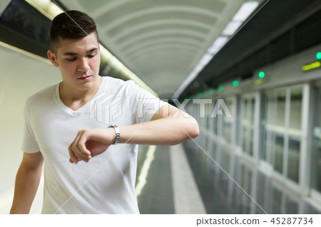 Man looking at watch on underground station Man looking at watch on underground station 45287734