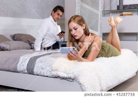 Girl with smartphone in bedroom Girl with smartphone in bedroom 45287738
