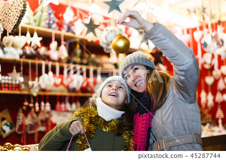 Young girl and her mother are choosing decorations for Christmas tree 45287744