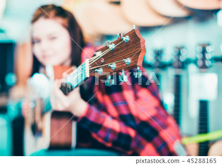 Teenage girl choosing acoustic guitar 45288165