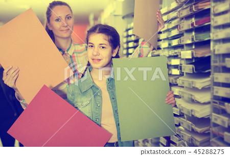 woman and girl shopping multicolored paper in art store 45288275