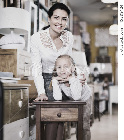 Adult female and her daughter are looking on new furniture in the store. Adult female and her daughter are looking on new furniture in the store. 45288424