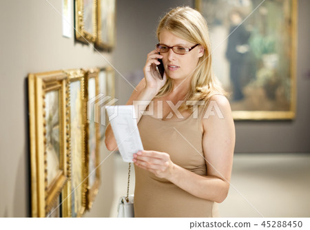 Woman with brochure looking at exposition Woman with brochure looking at exposition 45288450