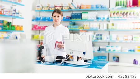 Woman pharmacist working behind counter Woman pharmacist working behind counter 45288455