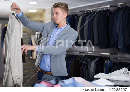 Man customer choosing colored jacket Man customer choosing colored jacket 45288567
