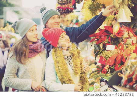 happy parents with teenage girl at counter with Poinsettia and floral decorations 45288788