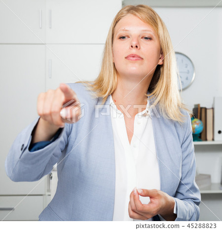 Business lady pointing to invisible screen 45288823