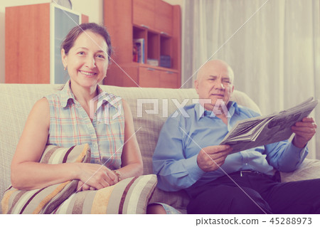 Happy couple of grandparents with newspaper 45288973