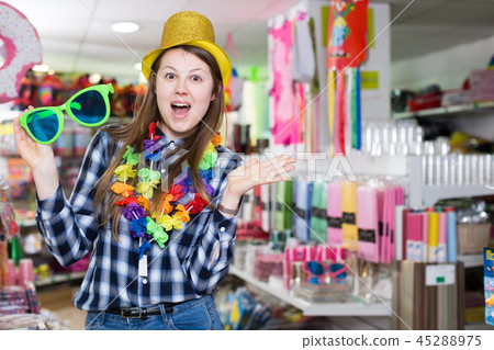 Girl joking in festive accessories shop 45288975
