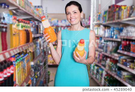 Happy woman in the supermarket buying juice 45289040
