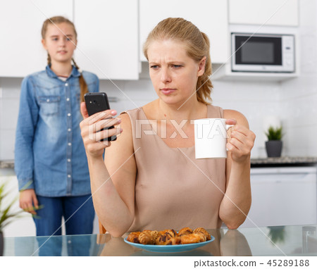 Woman having breakfast and holding smartphone 45289188