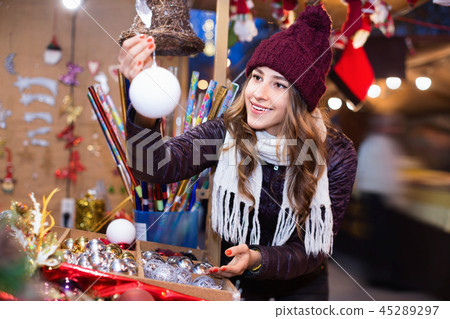 Beautiful young girl choosing Christmas decoration 45289297