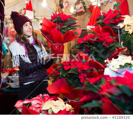 Girl buying Christmas floral compositions Girl buying Christmas floral compositions 45289320