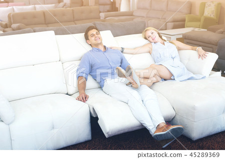 Young couple admire new sofa-transformer Young couple admire new sofa-transformer 45289369