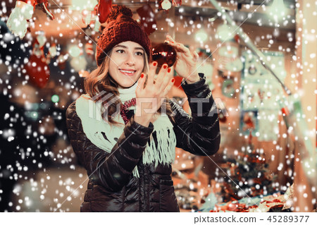 Beautiful girl choosing Christmas decoration Beautiful girl choosing Christmas decoration 45289377