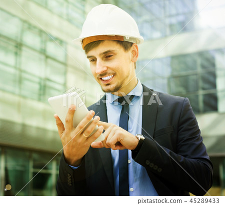 Smiling man working outdoors at modern touchpad 45289433