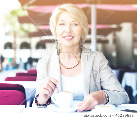 Portrait of elegant mature female who is enjoying of lunch with coffee Portrait of elegant mature female who is enjoying of lunch with coffee 45289638