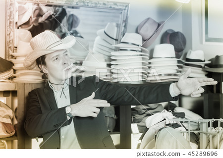 happy adult male try on cowboy hat at the shopping center 45289696