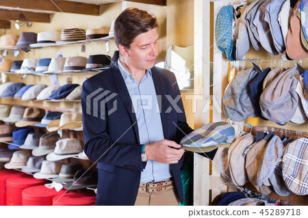 Portrait of male try on beret at the shopping mall Portrait of male try on beret at the shopping mall 45289718