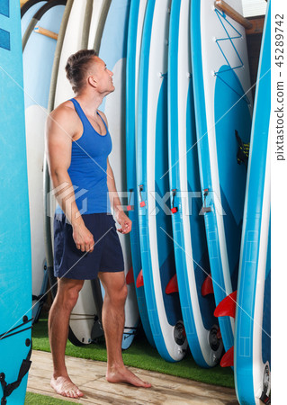 guy surfer choosing surfboard 45289742