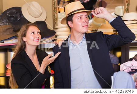 young female and man choosing hats in the store 45289749