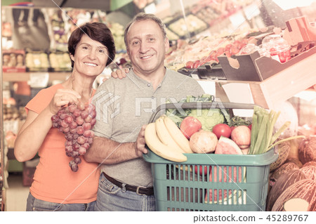 Smiling family standing with basket with products Smiling family standing with basket with products 45289767