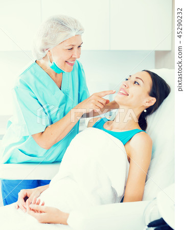 Cosmetician explaining treatment to patient 45290232