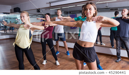 People learning zumba elements together in dancing class 45290441