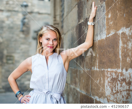 smiling woman near the stone wall 45290637