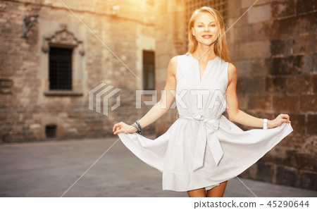 smiling woman holding dress in the hand 45290644