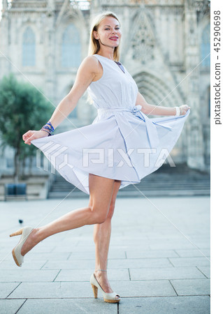 smiling woman holding dress in the hand 45290698