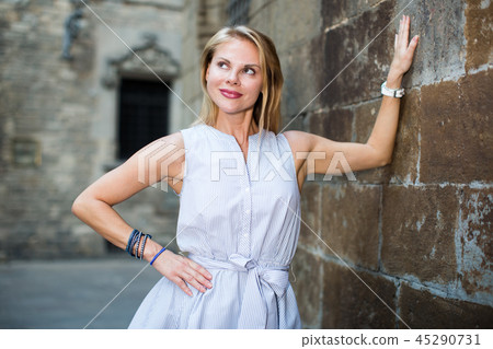 smiling woman near the stone wall 45290731