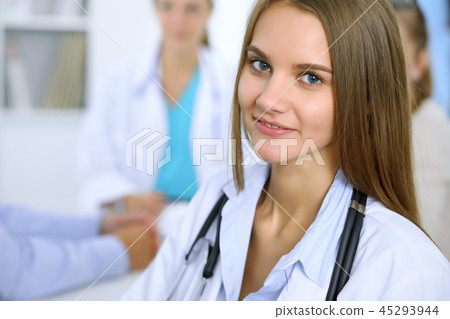 Happy doctor woman  with medical staff at the background in hospital office 45293944