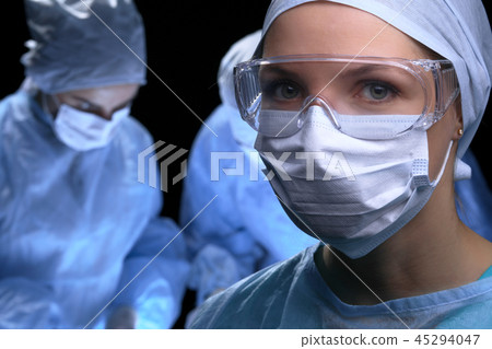 Medical team performing operation. Focus at female doctor Medical team performing operation. Focus at female doctor 45294047