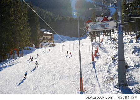 The skiers are on slope near cableway station 45294457