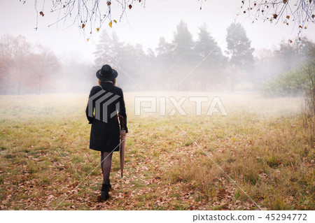 Woman in a coat in foggy weather 45294772