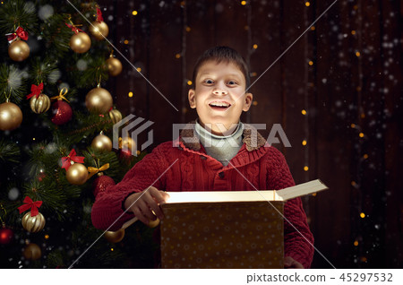 child boy sit with gift box near christmas tree child boy sit with gift box near christmas tree 45297532