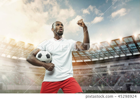 The football player in motion on the field of stadium The football player in motion on the field of stadium 45298924