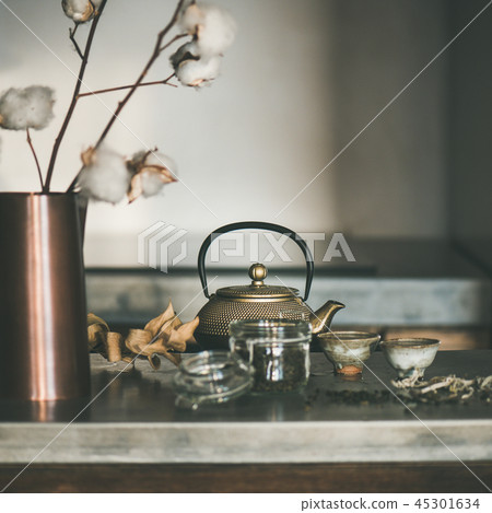Golden teapot and cups on concrete counter, square crop Golden teapot and cups on concrete counter, square crop 45301634