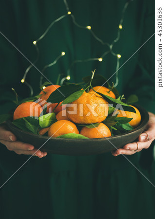 Fresh tangerine fruit in plate in female hands Fresh tangerine fruit in plate in female hands 45301636