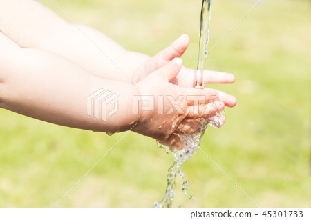 The small hand of the toddler washing his hands in the water. Clean, hygiene, cold, flu prevention image The small hand of the toddler washing his hands in the water. Clean, hygiene, cold, flu prevention image 45301733