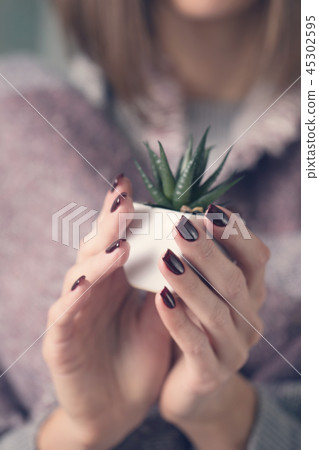 Girl holding a pot with a flower Girl holding a pot with a flower 45302595