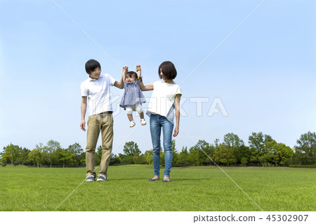 Happy young couple playing with their little daughter in the park on green grass. Affection, happiness, parent and child, family image Happy young couple playing with their little daughter in the park on green grass. Affection, happiness, parent and child, family image 45302907