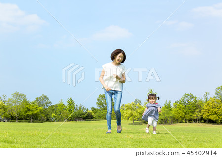 Happy mom running with little girl in park on green grass. Affection, happiness, child care, parent and child, family image Happy mom running with little girl in park on green grass. Affection, happiness, child care, parent and child, family image 45302914