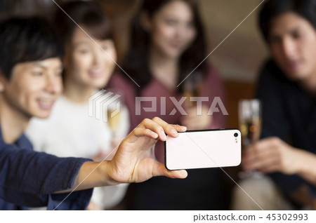 在聚會上採取自拍照的男人和女人 45302993
