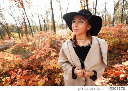 woman in dress and hat on background of autumn foliage 45303178