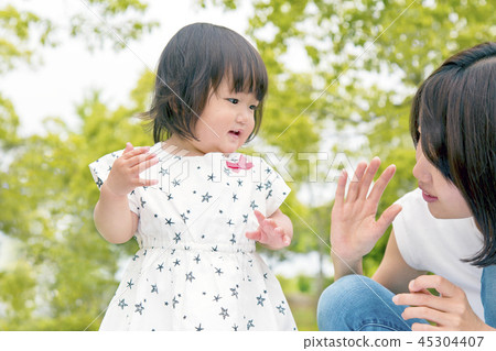 Young mom playing with her little daughter in the fresh green park. Parent-child, family, love, happiness image Young mom playing with her little daughter in the fresh green park. Parent-child, family, love, happiness image 45304407