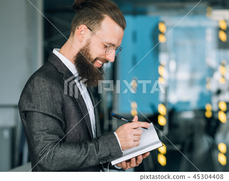 smiling man writing daily planner business agenda smiling man writing daily planner business agenda 45304408