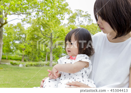 使用與她的小女兒的年輕媽媽在新鮮的綠色公園。親子,家庭,愛情,幸福形象 使用與她的小女兒的年輕媽媽在新鮮的綠色公園。親子,家庭,愛情,幸福形象 45304413
