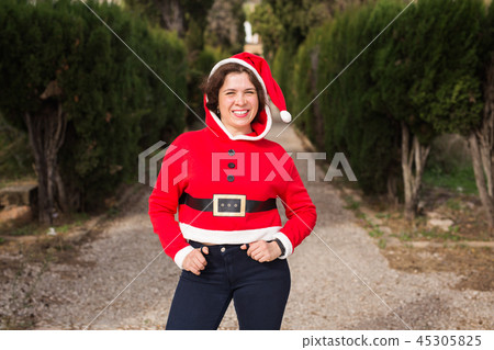 Christmas, holidays, humor and people concept - funny happy woman in santa suit dancing outdoors Christmas, holidays, humor and people concept - funny happy woman in santa suit dancing outdoors 45305825